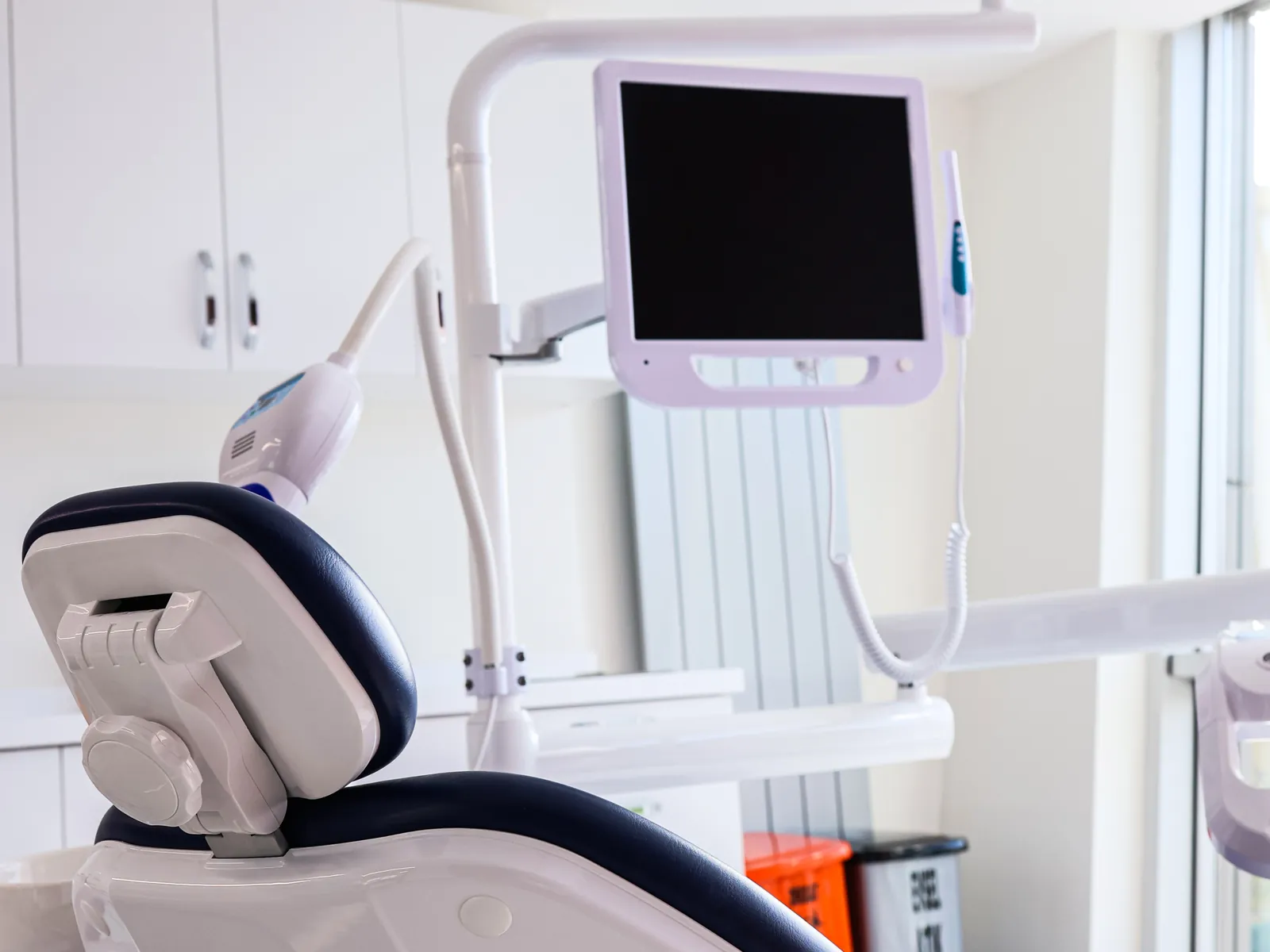 A dental chair and monitor in a treatment room