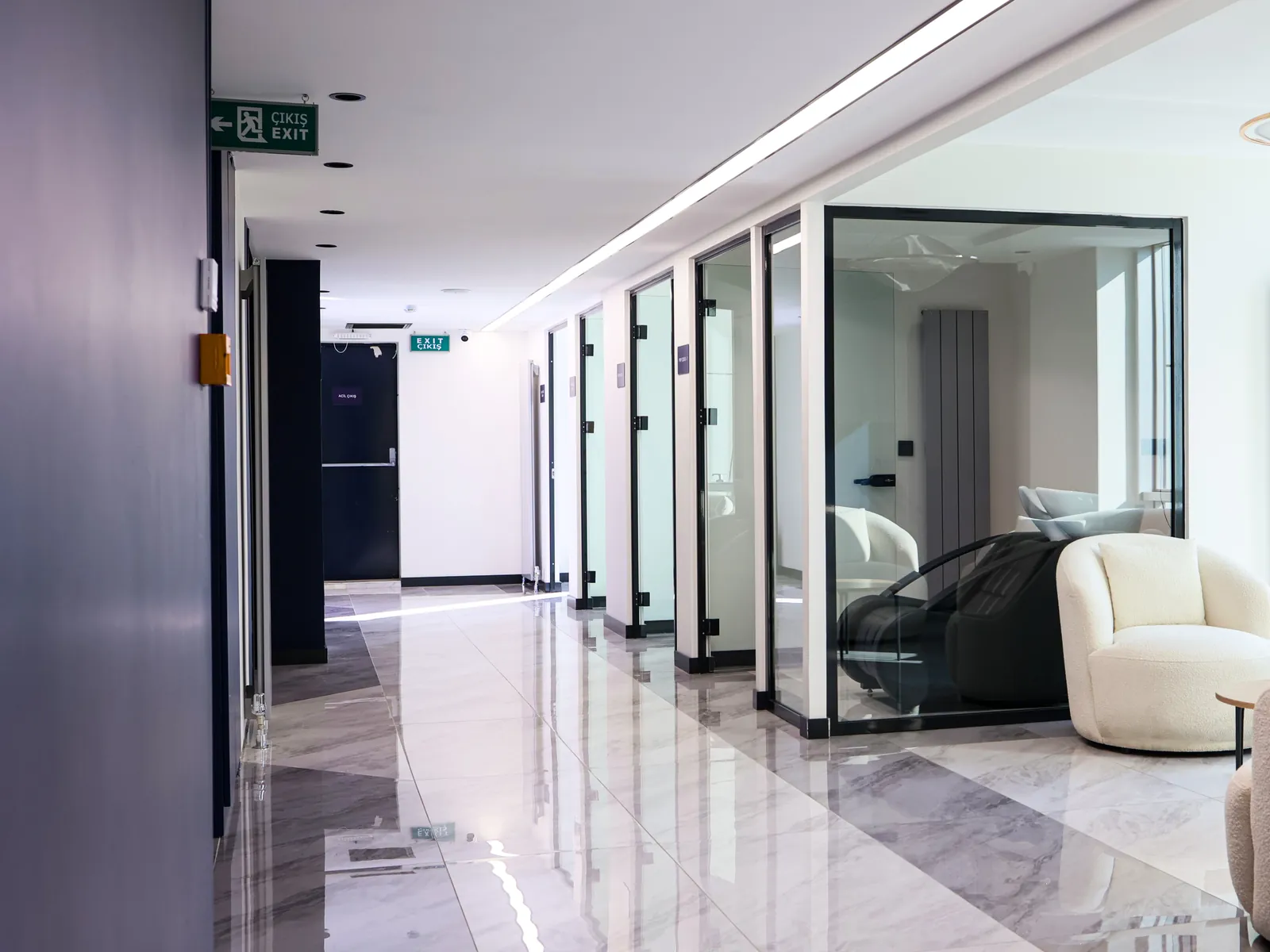 A corridor with glass-walled rooms inside the clinic